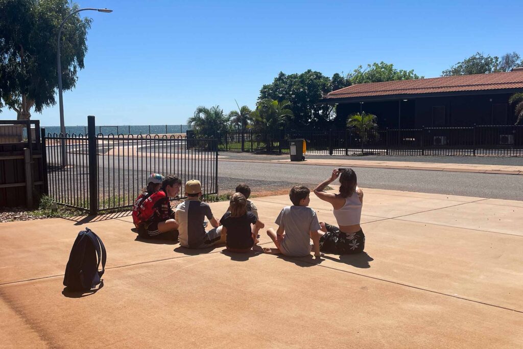 Marion Sonnenberg 和寄宿家庭的孩子们坐在前院的地板上。